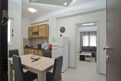 a kitchen and dining room with a table and a refrigerator at Sofia's Home Piraeus Modern, Reno, Fully Equipped in Piraeus