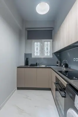 a large kitchen with white cabinets and a sink at Athens Oasis - Timeless comfort at the Acropolis in Athens