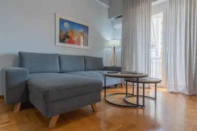 a living room with a blue couch and a table at Athens Oasis - Timeless comfort at the Acropolis in Athens