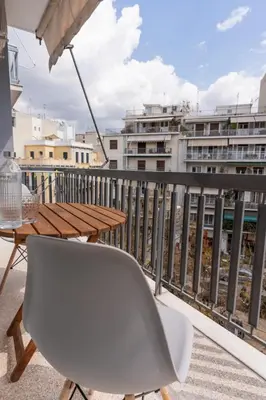 a table and a chair on a balcony at Athens Oasis - Timeless comfort at the Acropolis in Athens