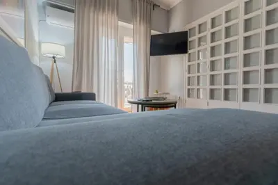 a bedroom with a blue bed and a window at Athens Oasis - Timeless comfort at the Acropolis in Athens