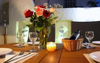 a table with a vase of roses and a candle at KG Acropolis Escape Spa Apartment in Athens