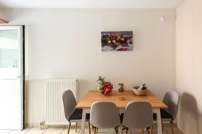 a dining room table with chairs and a painting on the wall at KG Acropolis Escape Spa Apartment in Athens