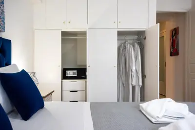 a bedroom with a bed and white cabinets at KG Acropolis Escape Spa Apartment in Athens