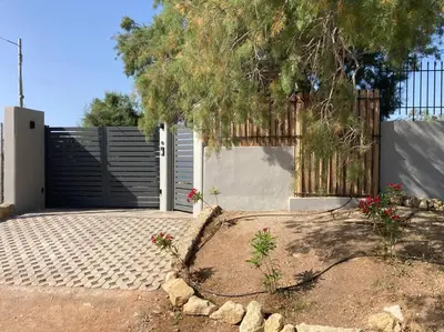 a driveway with a fence and a gate with flowers at Villa Tholos -Athens Riviera in Kalívia Thorikoú