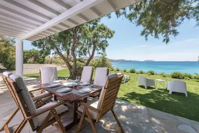 a table and chairs on a patio with a view of the ocean at Villa Tholos -Athens Riviera in Kalívia Thorikoú