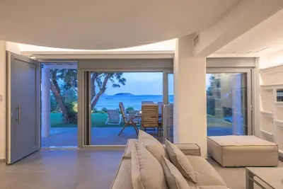 a living room with a couch and a view of the ocean at Villa Tholos -Athens Riviera in Kalívia Thorikoú