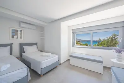 a white bedroom with two beds and a window at Villa Tholos -Athens Riviera in Kalívia Thorikoú