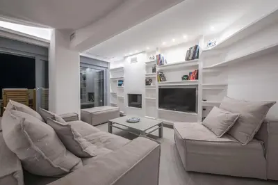 a living room with a couch and a tv at Villa Tholos -Athens Riviera in Kalívia Thorikoú