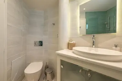 a white bathroom with a sink and a toilet at Villa Tholos -Athens Riviera in Kalívia Thorikoú
