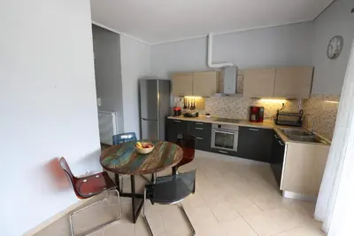 a kitchen with a table and chairs in a room at House in riviera lagonisi in Kalívia Thorikoú