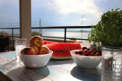 a table with two bowls of fruit on a table at House in riviera lagonisi in Kalívia Thorikoú