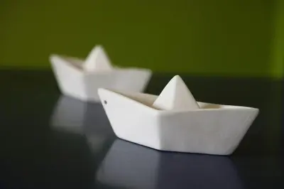 two white paper boats sitting on a table at House in riviera lagonisi in Kalívia Thorikoú