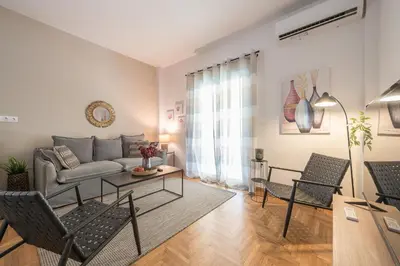 a living room with a couch and a table and chairs at Athens Gem in Koukaki in Athens