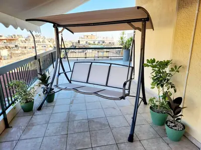a metal swing on a balcony with plants at Attiki Rooftop Apartment VIPGreece in Athens