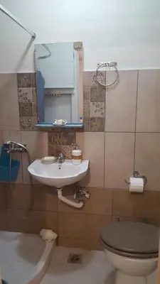 a bathroom with a sink and a toilet and a mirror at Comfy home 35sqm near National Garden in Athens