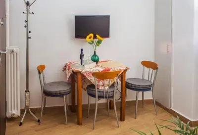 a table with four chairs and a vase with flowers on it at Cozy Athens Hideaway in Athens