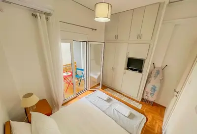 a bedroom with a white bed and a balcony at Cozy Athens Hideaway in Athens