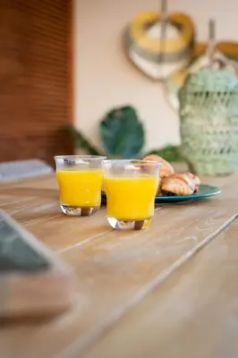 two glasses of orange juice and a plate of food at Villa Antiope Saronida in Saronida