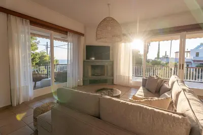 a living room with a couch and a fireplace at Villa Antiope Saronida in Saronida