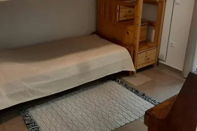 a bedroom with a bed and a dresser and a rug at Το σπίτι του καπετάνιου στη Βουλιαγμένη in Athens