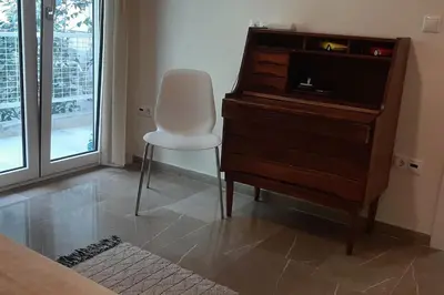 a bedroom with a dresser and a chair next to a desk at Το σπίτι του καπετάνιου στη Βουλιαγμένη in Athens