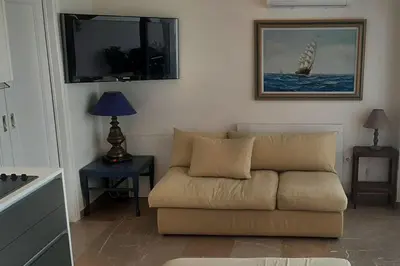 a living room with a couch and a picture on the wall at Το σπίτι του καπετάνιου στη Βουλιαγμένη in Athens