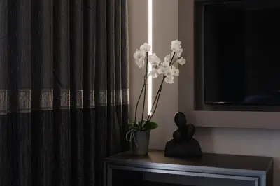 a vase with white flowers on a table next to a curtain at Golden Island Resorts in Athens