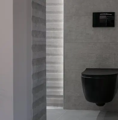 a bathroom with a black toilet and a wall at Golden Island Resorts in Athens