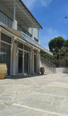 a building with a balcony and a patio at Euphoria Estate in Agia Marina Aegina