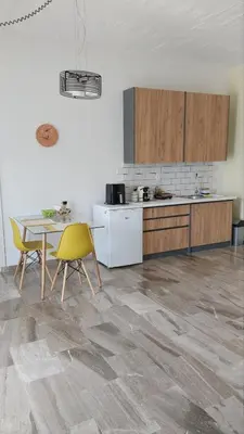 a kitchen with a table and yellow chairs in a room at Euphoria Estate in Agia Marina Aegina