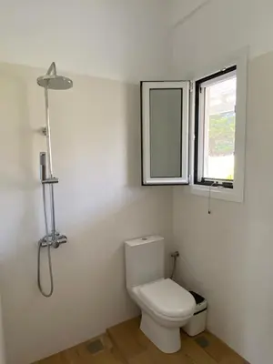 a bathroom with a toilet and a window at Euphoria Estate in Agia Marina Aegina
