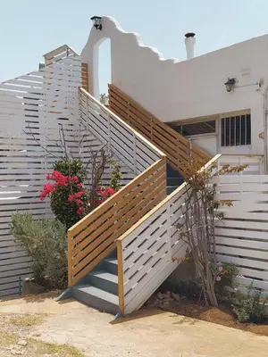 a staircase leading up to a house with flowers at BY THE SEA ROOMS, AVLAKI in Porto Rafti