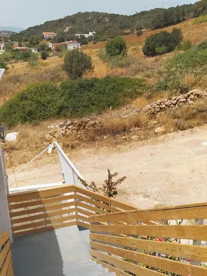 a wooden fence on the side of a house at BY THE SEA ROOMS, AVLAKI in Porto Rafti
