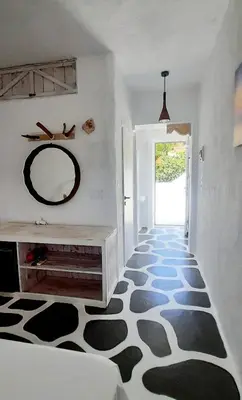 a hallway with a black and white floor with a mirror at BY THE SEA ROOMS, AVLAKI in Porto Rafti