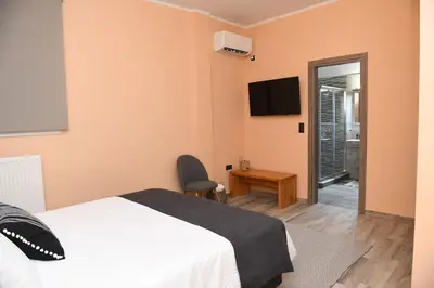 a bedroom with a bed and a chair and a television at Konstantina Apartment in Athens