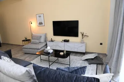 a living room with a couch and a flat screen tv at Konstantina Apartment in Athens