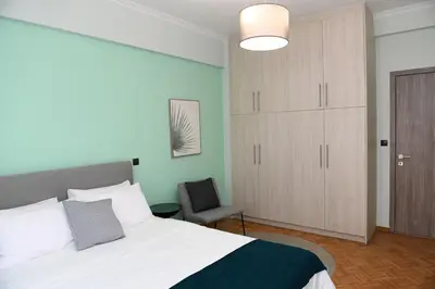 a bedroom with a bed and a cabinet and a chair at Konstantina Apartment in Athens