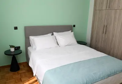 a bedroom with a large bed with white sheets and pillows at Alkmini Apartment in Athens