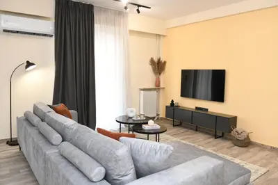a living room with a couch and a flat screen tv at Alkmini Apartment in Athens