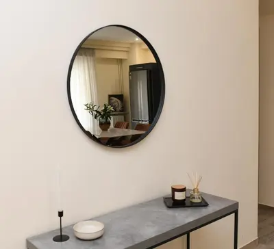 a mirror on a white wall in a bathroom at Alkmini Apartment in Athens