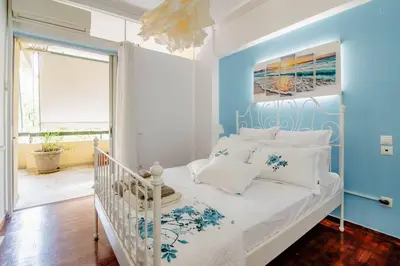 a bedroom with a white bed with blue walls at Athens Paradise Apartament 50 sqm Near To Metro #2 in Athens