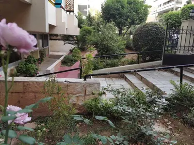 a set of stairs leading to a building with pink flowers at Athens Paradise Apartament 50 sqm Near To Metro #2 in Athens