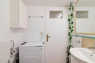 a white bathroom with a sink and a mirror at Athens Paradise Apartament 50 sqm Near To Metro #2 in Athens