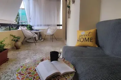 a living room with a couch and a book on a table at Athens Paradise Apartament 50 sqm Near To Metro #2 in Athens