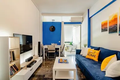 a living room with a blue couch and a table at Athens Paradise Apartament 50 sqm Near To Metro #2 in Athens