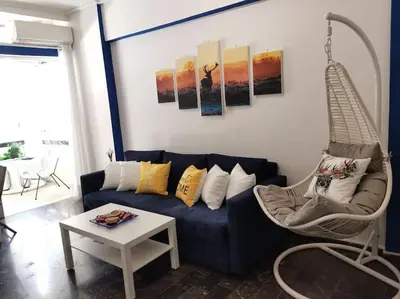 a living room with a blue couch and a chair at Athens Paradise Apartament 50 sqm Near To Metro #2 in Athens