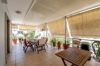 a patio with a table and chairs and plants at Evie's cozy apartment in Athens