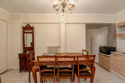 a kitchen with a dining room table and a refrigerator at Evie's cozy apartment in Athens