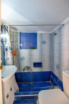 a blue tiled bathroom with a shower and a sink at Evie's cozy apartment in Athens
